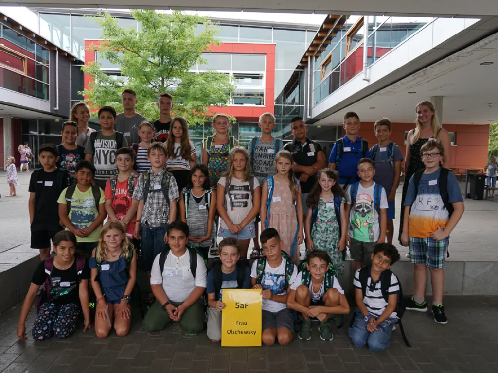 Klassenfoto einer neuen fünften Klasse mit gelbem Schild.